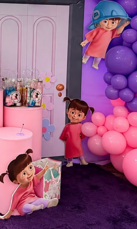 Purple and pink children’s party display with character cutouts and balloon garland