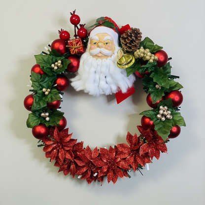 Handcrafted Christmas wreath with Santa face, red flowers, ornaments, and greenery